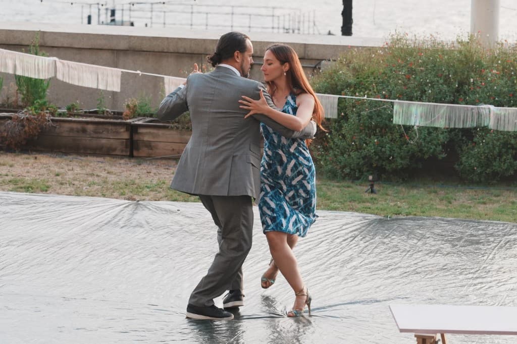 Couple performing Argentine tango on an outdoor dance floor