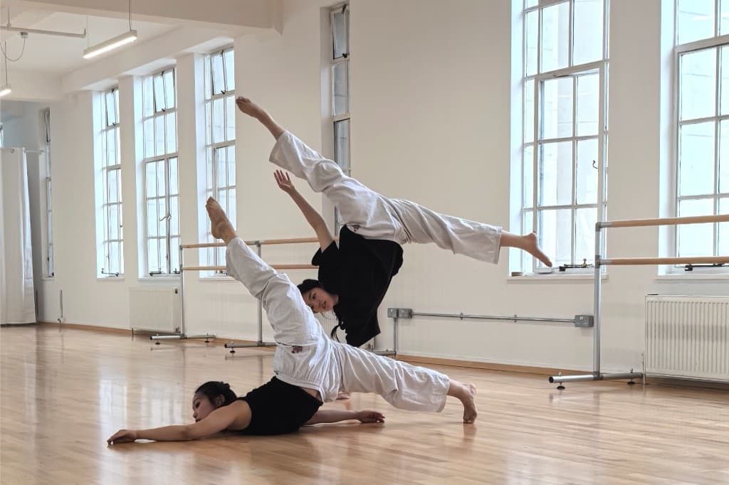Contemporary dancers in a bright venue with ballet barres