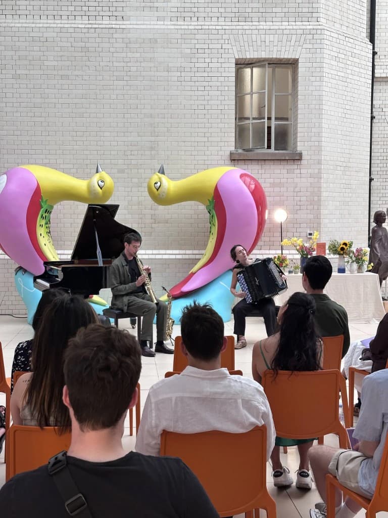 Saxophone and accordion performance beside colourful sculptures at County Hall